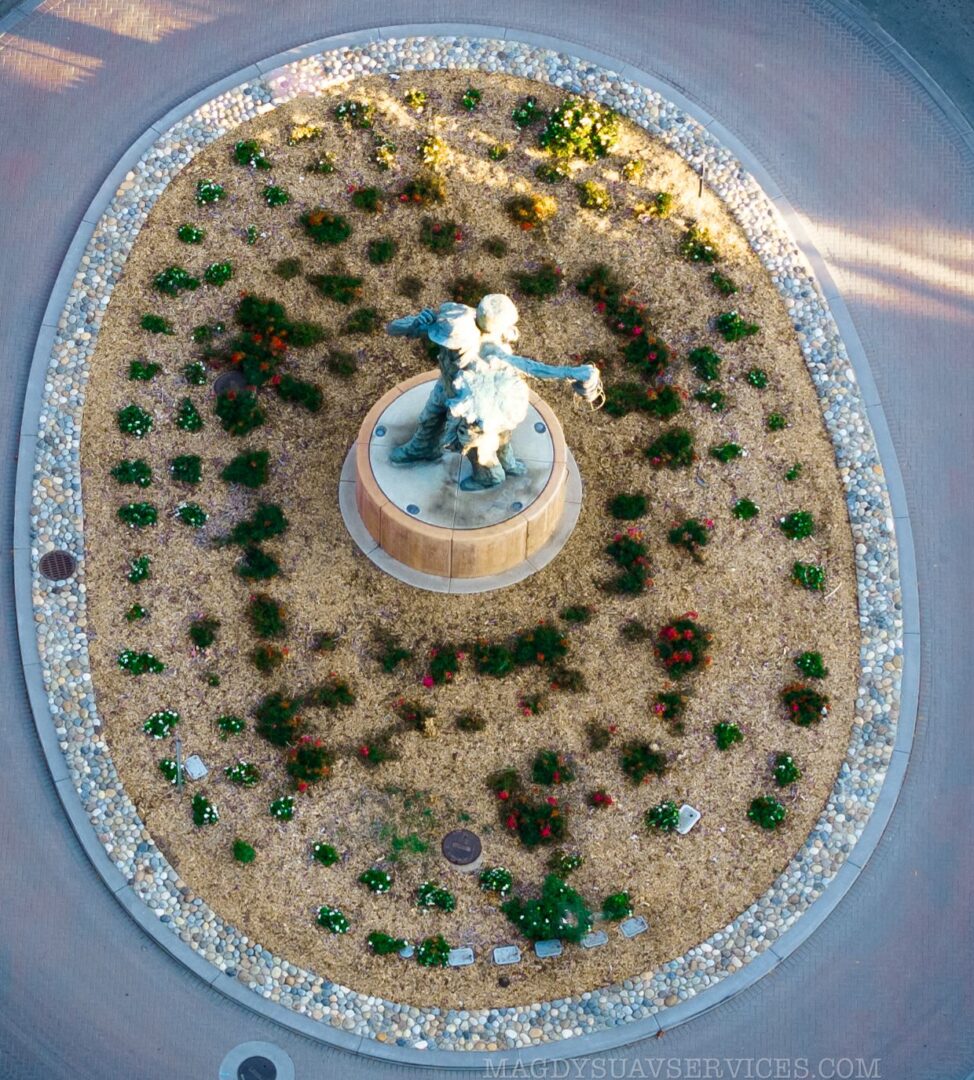 A circular garden with plants and rocks around it.