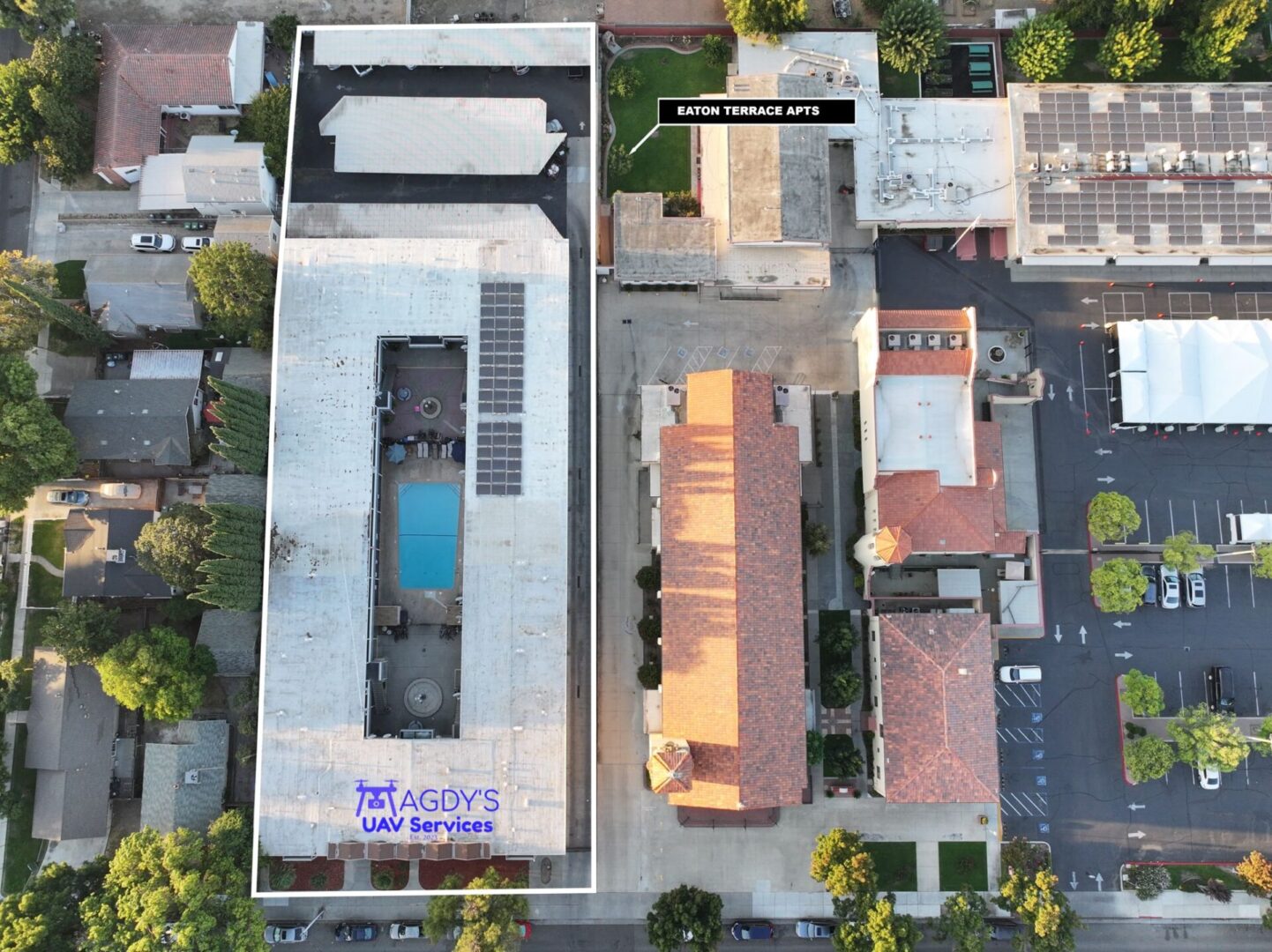 An aerial view of a building with a pool in the middle.